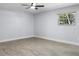 Bedroom with a wood-look floor, ceiling fan, and a window letting in natural light at 1011 Indian Oaks W, Daytona Beach, FL 32117
