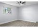 This bright bedroom includes a ceiling fan and a window overlooking the lush exterior at 1011 Indian Oaks W, Daytona Beach, FL 32117