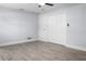 Bright bedroom featuring gray wood floors, ceiling fan, closet, and base trim at 1011 Indian Oaks W, Daytona Beach, FL 32117