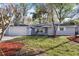 Attractive single-story home featuring a manicured lawn, mature trees, and an attached garage at 1011 Indian Oaks W, Daytona Beach, FL 32117