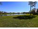 Expansive backyard view featuring a tranquil pond and lush green lawn on a sunny day at 1317 Dovercourt Ln, Ormond Beach, FL 32174