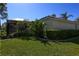 Well-maintained backyard with lush grass, privacy hedges, and a screened patio at 1317 Dovercourt Ln, Ormond Beach, FL 32174