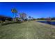 Expansive backyard with lush lawn, lake view, and mature trees, perfect for outdoor activities at 1317 Dovercourt Ln, Ormond Beach, FL 32174