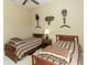 A bedroom with twin beds, a window with blinds, and wall decor at 1317 Dovercourt Ln, Ormond Beach, FL 32174