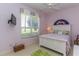 A light-purple bedroom featuring a bed, a window with blinds, and a ceiling fan at 1317 Dovercourt Ln, Ormond Beach, FL 32174