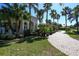 Stately home with lush landscaping, brick driveway, and multiple palm trees under a clear blue sky at 1317 Dovercourt Ln, Ormond Beach, FL 32174