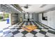 Spacious garage with checkered flooring, white cabinets, and natural light from windows at 1317 Dovercourt Ln, Ormond Beach, FL 32174