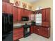 Efficient kitchen layout with dark wood cabinetry and stainless steel appliances at 1317 Dovercourt Ln, Ormond Beach, FL 32174