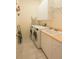 Functional laundry room with modern washer and dryer, storage cabinets, and a sink for added convenience at 1317 Dovercourt Ln, Ormond Beach, FL 32174