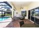 Covered patio with brick flooring, and comfortable seating, adjacent to the pool area at 1317 Dovercourt Ln, Ormond Beach, FL 32174