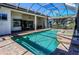 Backyard oasis with a sparkling pool, spa, brick pavers, and screened enclosure at 1317 Dovercourt Ln, Ormond Beach, FL 32174