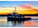 Scenic waterfront shot of a tugboat with a colorful sunset background at 14 Sea Swallow Ter, Ormond Beach, FL 32176