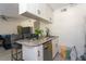 Cozy kitchen with granite countertops, white cabinetry, and stainless steel dishwasher, adjacent to a comfortable seating area at 1601 Big Tree Rd # 601, South Daytona, FL 32119