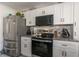 A well-appointed kitchen featuring white cabinets, granite counters, a stainless steel refrigerator, and modern appliances at 1601 Big Tree Rd # 601, South Daytona, FL 32119