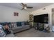 Cozy living room featuring a gray sectional, ceiling fan, and large television, creating an inviting space for relaxation and entertainment at 1601 Big Tree Rd # 601, South Daytona, FL 32119