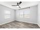Light-filled bedroom featuring modern ceiling fan, neutral walls, wood-look floors, and large windows with blinds at 168 Boynton Blvd, Daytona Beach, FL 32118