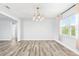 Bright dining room featuring wood floors, modern chandelier, and natural light from the window at 168 Boynton Blvd, Daytona Beach, FL 32118