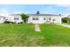 Front exterior featuring a white home, green lawn, and driveway at 168 Boynton Blvd, Daytona Beach, FL 32118