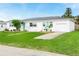 Charming one-story white home with a well-manicured lawn and a lovely turquoise-colored front door at 168 Boynton Blvd, Daytona Beach, FL 32118