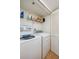 Functional laundry area featuring a washer, dryer, overhead shelving, and a louvered door at 4545 S Atlantic Ave # 3206, Port Orange, FL 32127