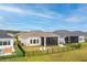 Aerial view of a home's fenced backyard, featuring a screened patio with outdoor seating and chairs at 604 Mosaic Blvd, Daytona Beach, FL 32124