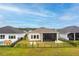 Aerial view of backyard with black fence, screened in patio with outdoor seating, and adjacent pool at 604 Mosaic Blvd, Daytona Beach, FL 32124