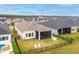 Aerial view showcases backyard with black fence, patio seating, and mature landscaping at 604 Mosaic Blvd, Daytona Beach, FL 32124