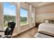 Relaxing bedroom with large windows showcasing a beautiful backyard and a comfortable desk setup at 604 Mosaic Blvd, Daytona Beach, FL 32124