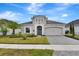 Inviting single-story house showcasing lush landscaping, a brick driveway, and a welcoming front entrance at 604 Mosaic Blvd, Daytona Beach, FL 32124