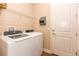 Well-lit laundry room featuring a white washer and dryer set and wire shelving for storage solutions at 604 Mosaic Blvd, Daytona Beach, FL 32124