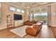Comfortable living room with tray ceilings, a large leather sofa, and floor-to-ceiling windows for natural light at 604 Mosaic Blvd, Daytona Beach, FL 32124