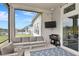 Relaxing screened patio with comfortable seating, outdoor television, and stainless steel grill at 604 Mosaic Blvd, Daytona Beach, FL 32124