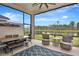 Spacious screened patio with dining and lounge areas, showcasing a backyard view of the lake at 604 Mosaic Blvd, Daytona Beach, FL 32124