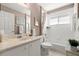 Bright bathroom featuring a vanity, commode, and tiled shower-tub combination at 6123 Jasmine Vine Dr, Port Orange, FL 32128