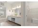 Bright bathroom featuring double sinks, a large mirror, and access to a walk-in closet at 6123 Jasmine Vine Dr, Port Orange, FL 32128