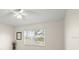 Well-lit bedroom with white ceiling fan, large window, and neutral walls at 6123 Jasmine Vine Dr, Port Orange, FL 32128