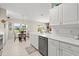 Open kitchen area with white cabinets, a stainless dishwasher, and a view into the breakfast nook at 6123 Jasmine Vine Dr, Port Orange, FL 32128