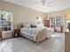 Bright main bedroom with tile floors, featuring two windows for natural light and an ensuite bathroom at 22527 Lake Seneca Rd, Eustis, FL 32736