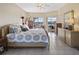 Bright and airy main bedroom with tile flooring, a ceiling fan, and windows offering views of the outdoors at 22527 Lake Seneca Rd, Eustis, FL 32736