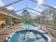 The screened-in pool and spa are perfect for outdoor relaxation, complemented by lush landscaping and sunny skies at 22527 Lake Seneca Rd, Eustis, FL 32736