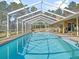 Screened-in pool is perfect for outdoor enjoyment, complemented by lush landscaping and clear blue skies at 22527 Lake Seneca Rd, Eustis, FL 32736