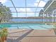 Sparkling screened-in pool overlooks a serene lake, offering a private outdoor oasis at 22527 Lake Seneca Rd, Eustis, FL 32736