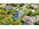 Aerial view of a home featuring a screened pool, surrounded by lush greenery and neighboring houses at 3428 Rexford Cir, Ormond Beach, FL 32174