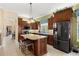 Well-lit kitchen features dark cabinetry, stainless steel appliances, and a center island with seating for casual dining at 3428 Rexford Cir, Ormond Beach, FL 32174