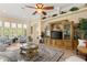 Bright living room featuring a large ceiling fan, wood flooring, and ample seating at 3428 Rexford Cir, Ormond Beach, FL 32174