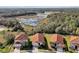 Aerial view of homes with terra cotta roofs, surrounded by lush greenery and a scenic lake backdrop at 410 Viola Dr, Davenport, FL 33837