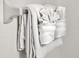 Fresh white towels folded and neatly arranged on a towel rack, showcasing a clean bathroom at 410 Viola Dr, Davenport, FL 33837