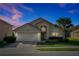 Charming single-story home with a two-car garage, manicured lawn and vibrant landscaping at 410 Viola Dr, Davenport, FL 33837