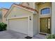 Close up of home's two car garage and front entrance with decorative glass side panel at 410 Viola Dr, Davenport, FL 33837