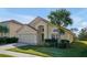 Lovely single-story home with lush lawn, mature palm, red tile roof and two-car garage at 410 Viola Dr, Davenport, FL 33837